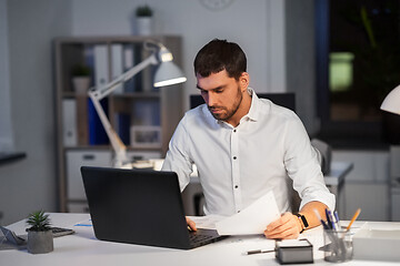 Image showing businessman with laptop working at night office