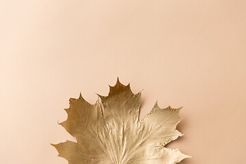 Image showing golden maple leaf on beige background