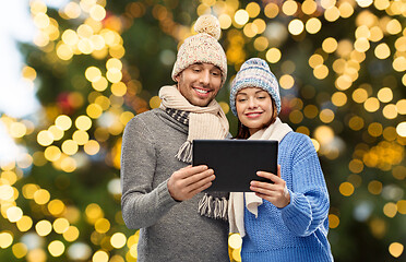 Image showing couple with tablet computer over christmas lights