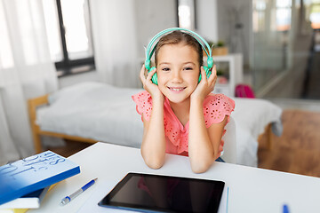 Image showing girl in headphones with tablet computer at home