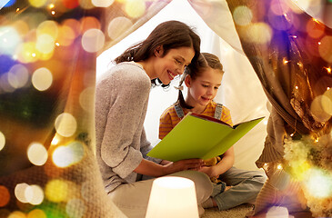 Image showing happy family reading book in kids tent at home