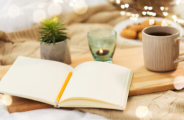 Image showing diary, tea and candle in holder at home