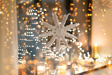 Image showing paper snowflake decoration hanging on window