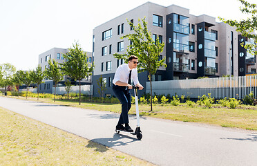 Image showing young businessman riding electric scooter outdoors