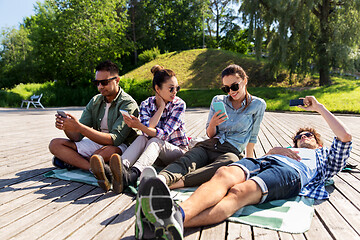 Image showing friends with smartphones at summer park