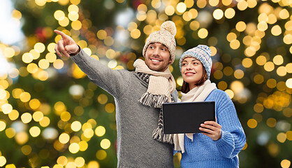 Image showing couple with tablet computer over christmas lights