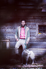 Image showing hipster with dog in front of wooden house