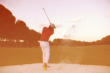 Image showing golfer hitting a sand bunker shot on sunset