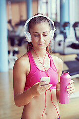 Image showing woman with headphones in fitness gym