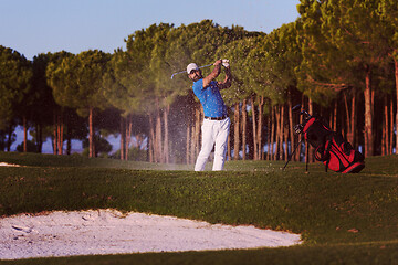 Image showing golfer hitting a sand bunker shot on sunset