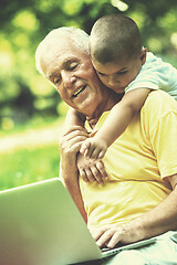 Image showing grandfather and child using laptop