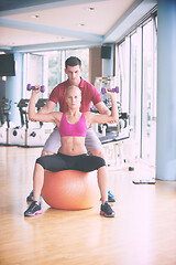 Image showing young sporty woman with trainer exercise weights lifting