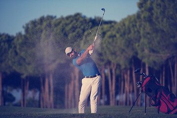 Image showing golfer hitting a sand bunker shot on sunset