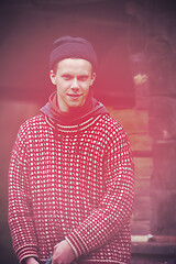 Image showing young hipster in front of wooden house