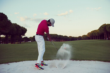 Image showing golfer hitting a sand bunker shot on sunset