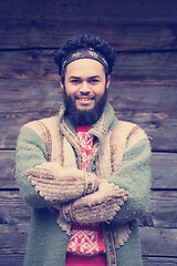 Image showing portrait of young hipster in front of wooden house