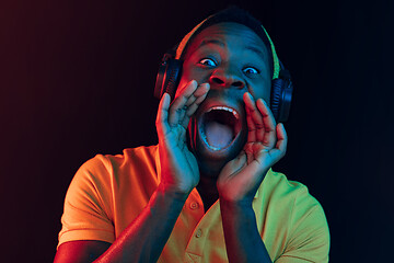 Image showing The young handsome hipster man listening music with headphones