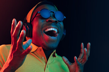 Image showing Young handsome hipster man listening music with headphones