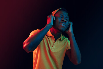 Image showing The young handsome hipster man listening music with headphones