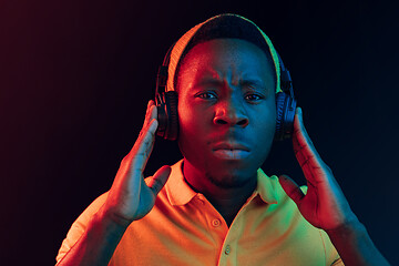 Image showing The young handsome hipster man listening music with headphones