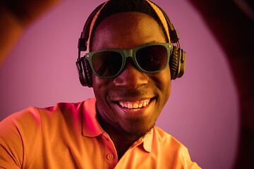 Image showing The young handsome hipster man listening music with headphones