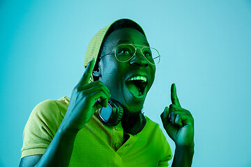 Image showing The young handsome hipster man listening music with headphones