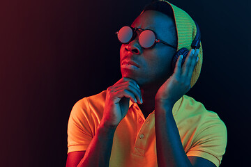 Image showing The young handsome hipster man listening music with headphones