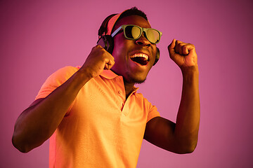 Image showing The young handsome hipster man listening music with headphones