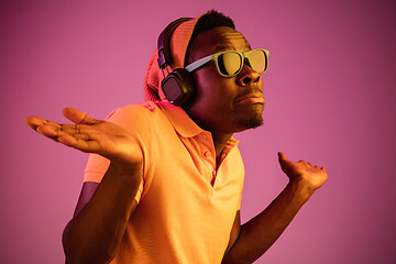 Image showing The young handsome hipster man listening music with headphones