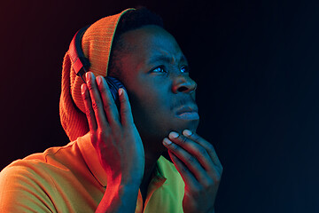 Image showing The young handsome hipster man listening music with headphones