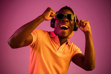 Image showing The young handsome hipster man listening music with headphones