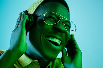 Image showing The young handsome hipster man listening music with headphones