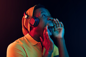 Image showing The young handsome hipster man listening music with headphones