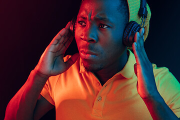 Image showing The young handsome hipster man listening music with headphones