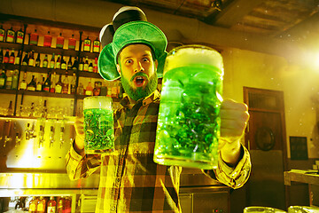 Image showing Happy man with glass of beer looking aside in pub