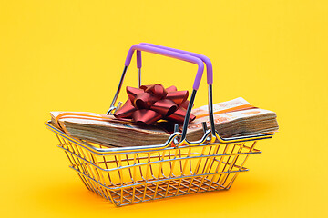 Image showing In the grocery basket is a bundle of money with a red bow