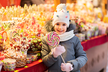 Image showing girl with lollipop at christmas market candy shop