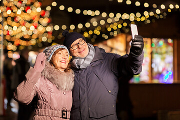 Image showing senior couple taking selfie at christmas market