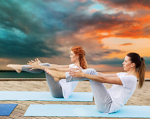 Image showing women making yoga in half-boat pose outdoors