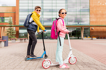 Image showing school children with backpacks riding scooters
