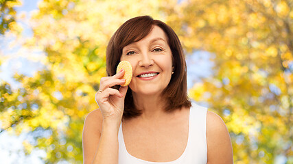 Image showing woman cleaning face with exfoliating sponge