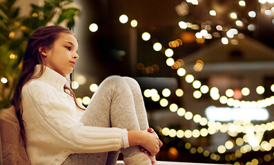 Image showing sad girl sitting at home window on christmas