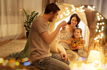 Image showing happy family playing in kids tent at night at home