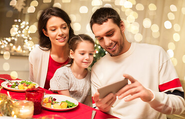 Image showing family with smartphone having christmas dinner