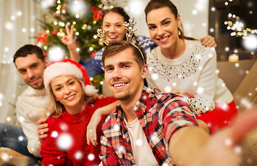 Image showing friends celebrating christmas and taking selfie