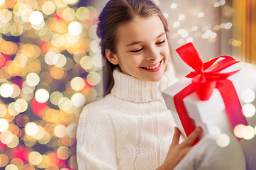 Image showing happy beautiful girl with christmas gift at home