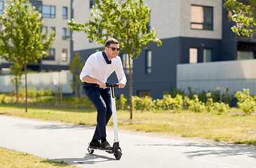 Image showing young businessman riding electric scooter outdoors