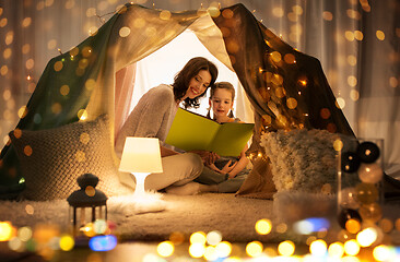 Image showing happy family reading book in kids tent at home