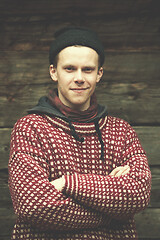 Image showing young hipster in front of wooden house