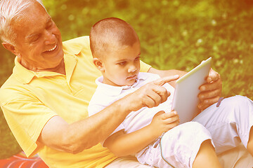 Image showing grandfather and child in park using tablet